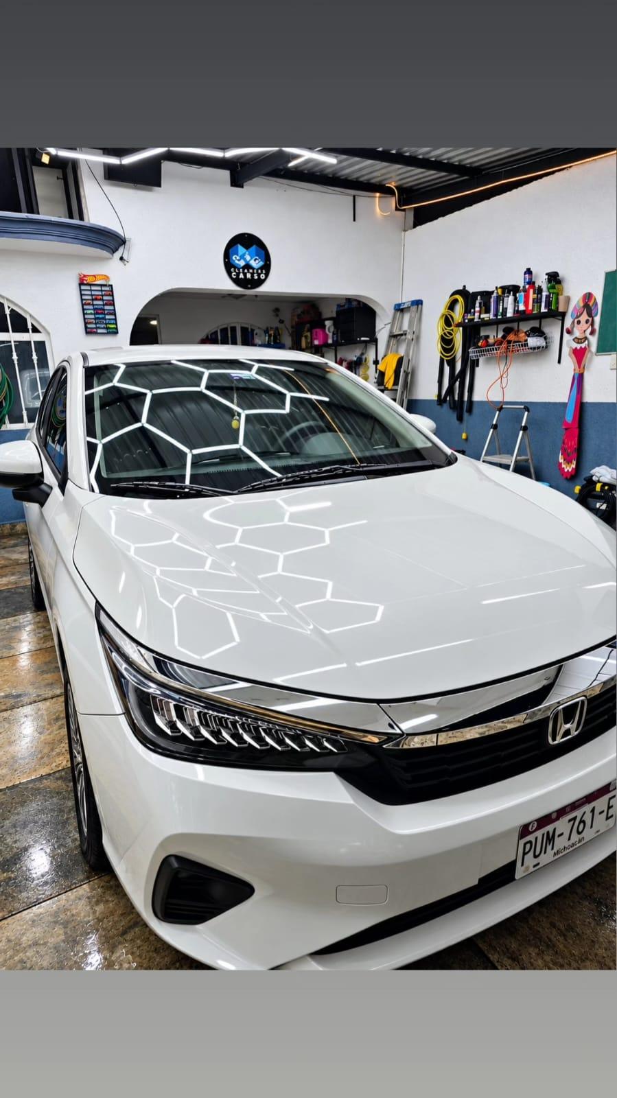 Auto blanco con acabado brillante en taller de lavado.